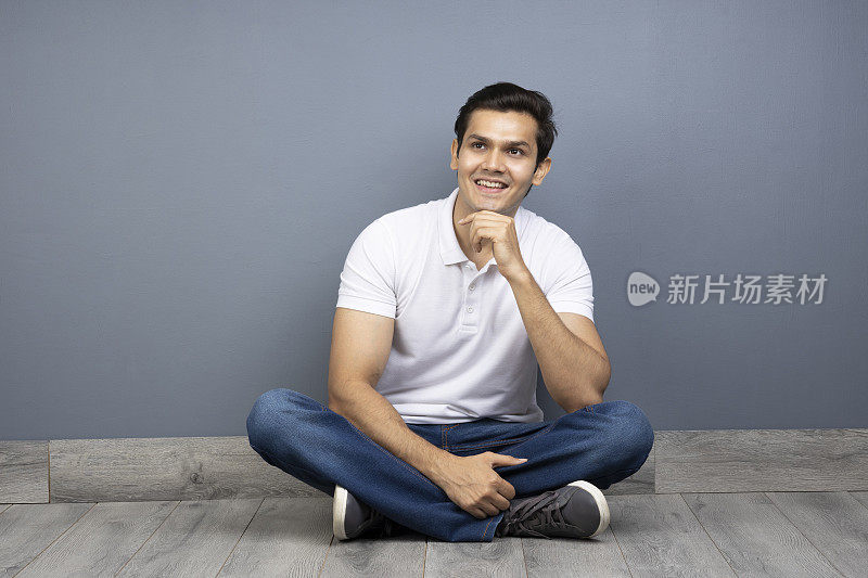 男人盘腿坐在地板上的stock photo